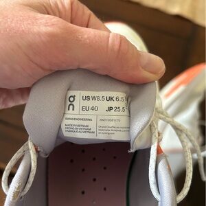 On Running White and Orange Athletic Shoes